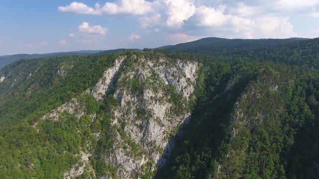 Aerial view of the dramatic limestone cliffs of Banjska Stena rising above dense green forests in Rastiste, Zlatiborski okrug, Serbia.