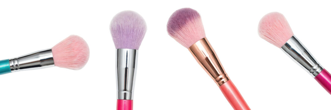 Four makeup brushes with soft pink and purple bristles and colorful handles arranged on a white surface isolated on a transparent background