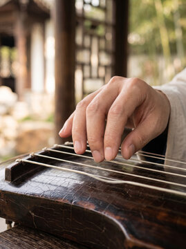 Musician Plucking Strings On Wooden Traditional Asian Guqin Instrument