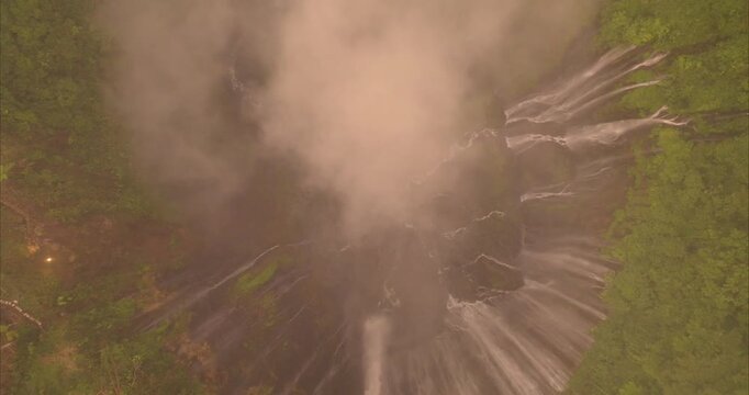 Aerial view of Tumpak Sewu Waterfall with cascading water and lush tropical greenery in Kecamatan Pronojiwo, Jawa Timur, Indonesia.