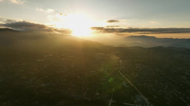 Golden hour aerial rotates to sun over city of Mutare, Zimbabwe