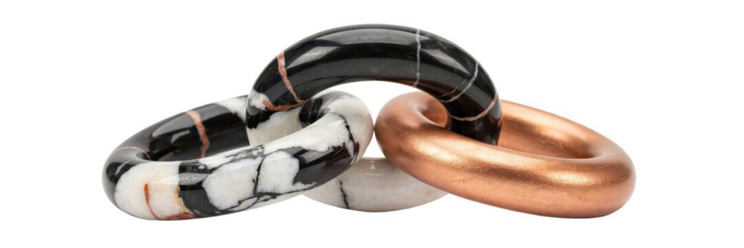Interlocking decorative rings made of polished black and white marble with a metallic copper ring isolated on a transparent background