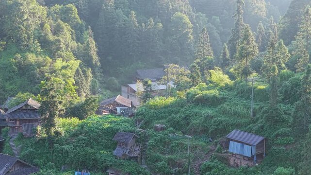 Aerial view of traditional wooden houses nestled in the lush green mountains of Yintan Shangzhai, Guizhou, China.