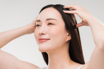 Fototapeta premium 頭皮マッサージでリフレッシュし目を閉じて微笑む日本人女性