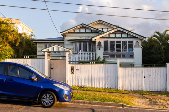 old gabled bungalow house with a car parked on the street in front