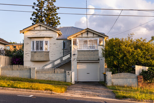 timber house with peeling paint in late afternoon light