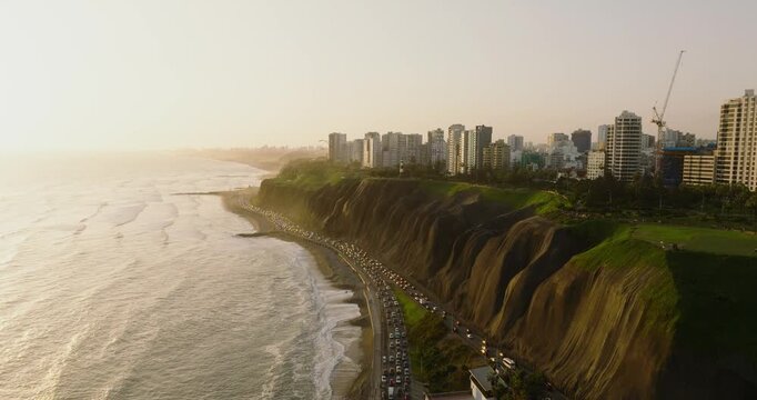 Aerial view of the dramatic coastal cliffs and urban skyline along the Pacific Ocean in Lima, Callao Region, Peru.