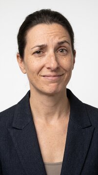 Middle aged professional woman with skeptical expression on white
