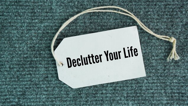 Tag the paper with the words Declutter your life. removing unnecessary physical objects, digital distractions, and mental commitments to create a more peaceful and focused existence.