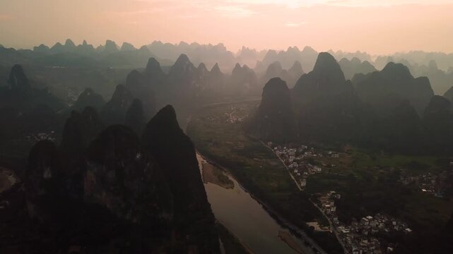 Aerial view of the iconic karst mountains and Li River winding through the landscape at sunset in Guilin, Guangxi, China.