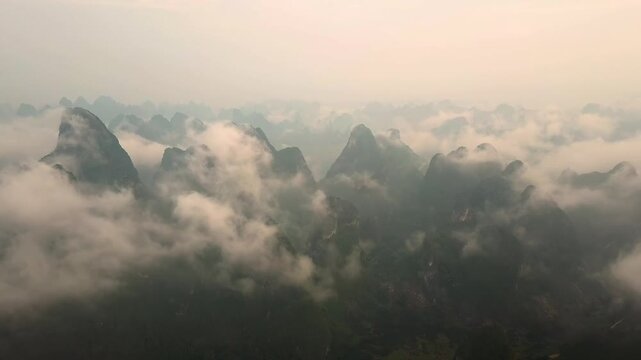 Aerial view of karst mountains shrouded in mist and clouds in Guilin, Guangxi, China.