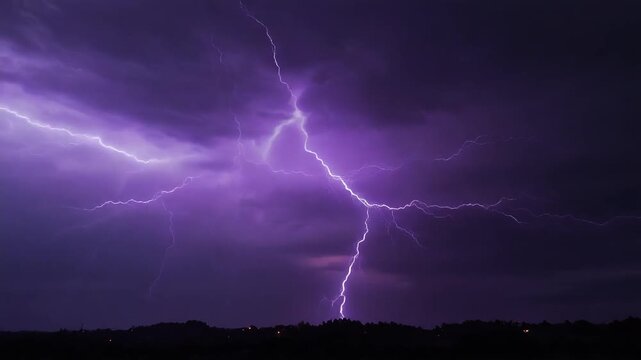 Vibrant purple lightning striking the dark night sky over a silhouette landscape during a violent thunderstorm