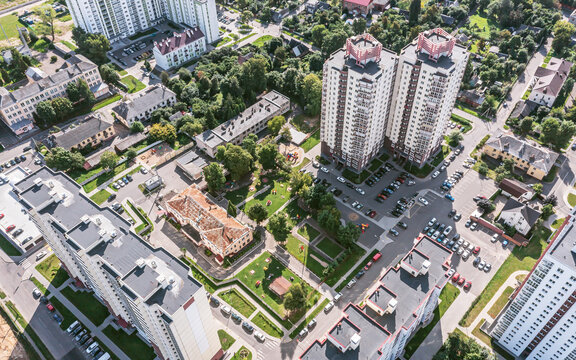 aerial view of residential neighborhood with children playgrounds and parking lots in courtyards on a sunny summer day.