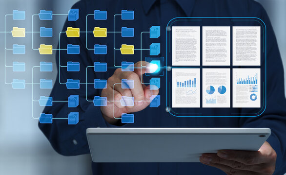 Business document management system DMS. Digital file database and document organization technology. Businessman touching file icon within folder structure on tablet.