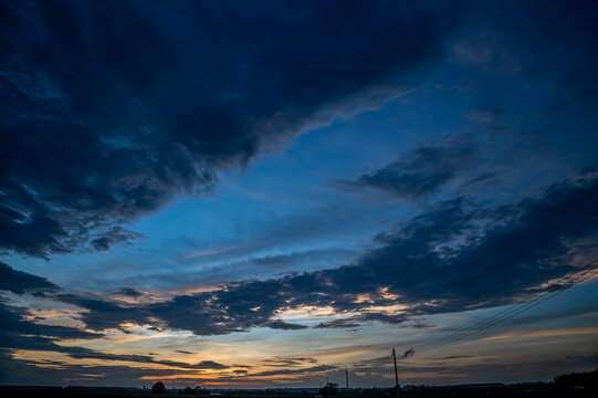 Dramatic Blue Dusk Sky with Stormy Dark Clouds and Sunset Horizon.