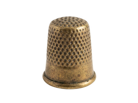 Vintage brass thimble with intricate perforated pattern sits on neutral background.