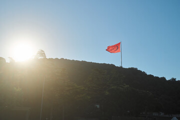 トルコ・イスタンブールの丘に掲げられた赤い旗と夕方の逆光シルエット © 佑樹 稲垣