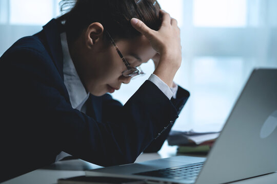 Businesswoman Thinking Deeply While Working on Laptop in Modern Office, Representing Business Decisions, Work Pressure and Problem Solving. 