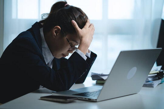 Businesswoman Thinking Deeply While Working on Laptop in Modern Office, Representing Business Decisions, Work Pressure and Problem Solving. Stressed Businessman Working at Office Desk,