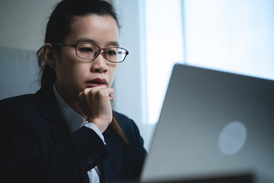 Businesswoman Thinking Deeply While Working on Laptop in Modern Office, Representing Business Decisions, Work Pressure and Problem Solving. Working at Office Desk,
