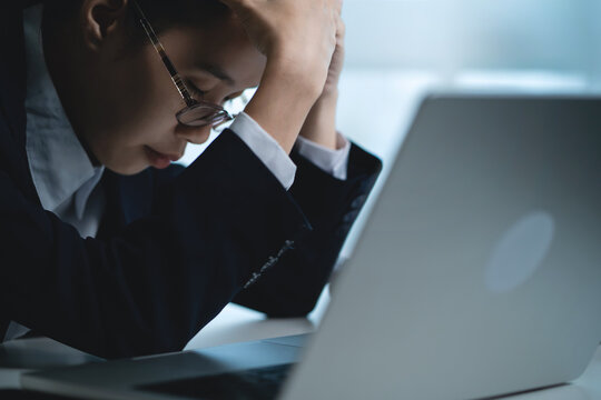 Businesswoman Thinking Deeply While Working on Laptop in Modern Office, Representing Business Decisions, Work Pressure and Problem Solving. 