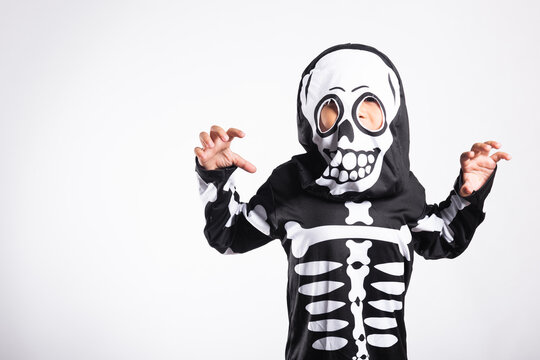Halloween celebration featuring kid in spooky costume acting playful for scary party holiday event while posing against bright white background backdrop for fun seasonal photography concept