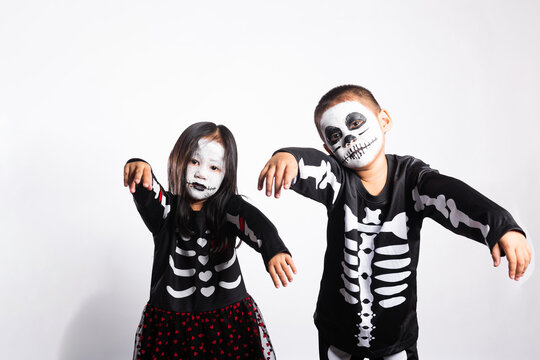 Halloween party featuring cute kid characters wearing costume makeup, posing playfully together in bright white studio environment for spooky autumn festival celebration