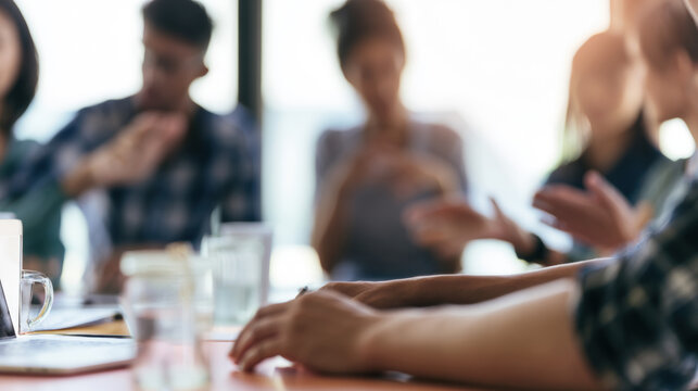 People sitting in a meeting room discussing and sharing ideas on a project in a bright space with natural light