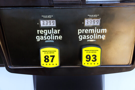 Two fuel pumps show prices for regular, premium gasoline these signs are located at city gas station