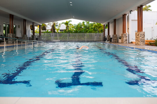 woman swimming laps in a resort pool