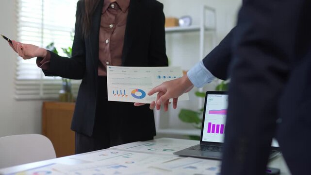Businesswoman presenting financial data analysis and market research to a colleague during a corporate meeting in the office