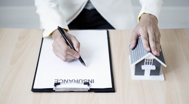 Real estate agent agents working in real estate investment and home insurance signing contracts in accordance with the home buying insurance agreements approving purchases for clients