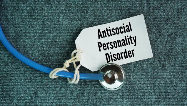Stethoscope and paper tag with the words Antisocial personality disorder. mental health condition defined by a chronic, pervasive pattern of ignoring, exploiting, or violating the rights 