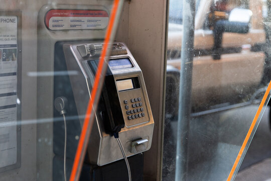 Public payphone inside a glass booth
