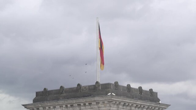 German Flag on Pole Waving Against Cloudy Sky Berlin
