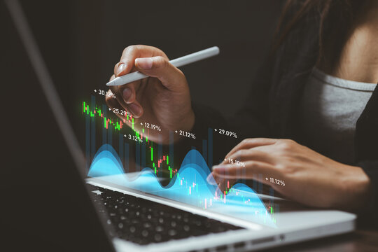 Business professional analyzing market data on a laptop with digital stock charts, representing investment research, trading, analytics, fintech, economic trends, and business strategy.