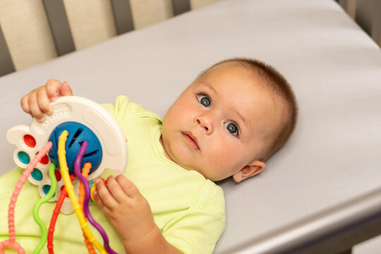 Curious Baby Son Examining Interactive Sensory Toy At Home
