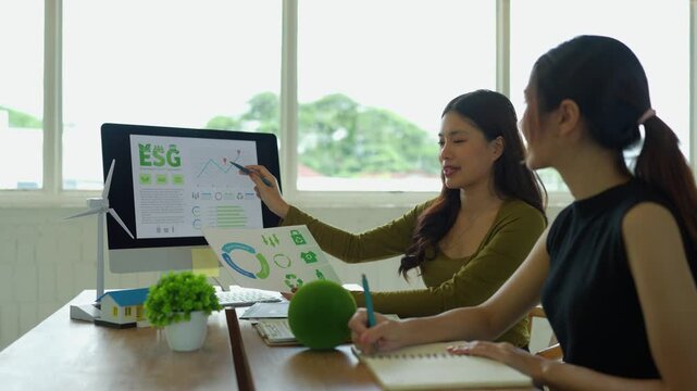 Asian businesswomen discussing ESG environmental social and governance investment strategy in a modern office meeting