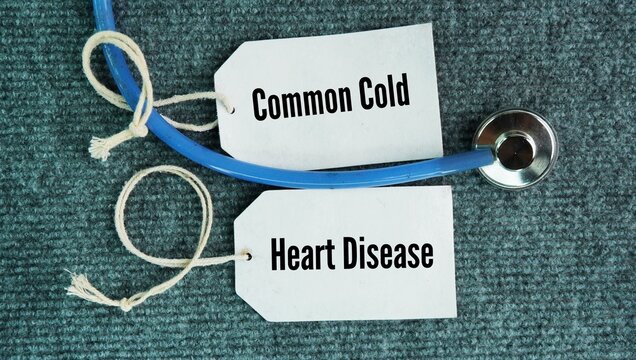 Stethoscope and paper tag with words common cold and heart disease. They affect millions of people every year. What are the two common diseases?