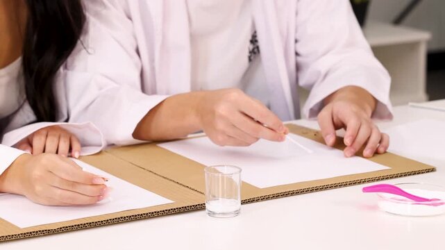 Student in Lab Coat Performing Science Experiment with Cotton Swab