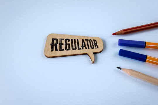 REGULATOR Message on a Wooden Speech Bubble With Stationery