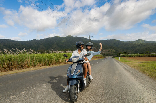 Young couple taking a selfie on a scooter