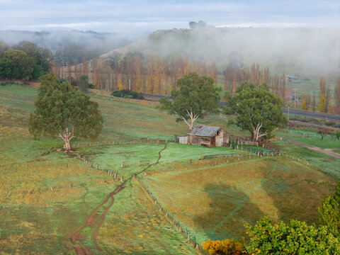 Old rustic farmhouse surrounded by misty paddocks in rural Australian countryside