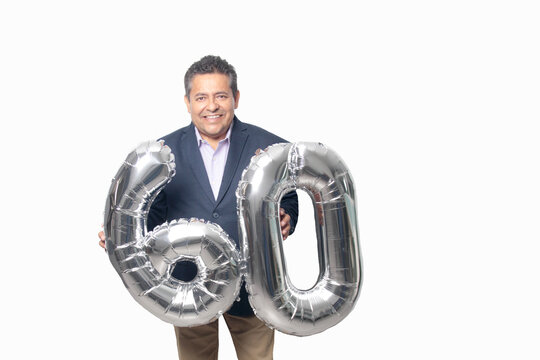 60-year-old Latino man with a dark skin displays 60 shaped balloons to celebrate his birthday and his entry into his old age