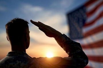 Fototapeta premium Soldier salutes at sunset, flag blurred in background. Backlit figure shows solemn commitment and pride. Golden light glows behind disciplined posture. Ideal for military, patriotism