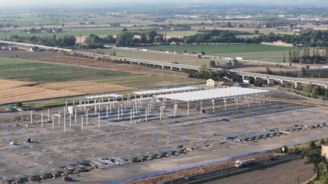 AKNO Fiorenzuola Business Park develops across large graded construction grounds in Fiorenzuola d'Arda, Piacenza, near the A1 and A21 link road, drone static.