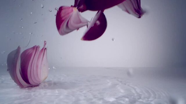 Red Onion Slices Dropping into Water Creating Splashes Slow Motion Stock Video