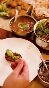 Close Up of Hand Eating Indian Cuisine at Restaurant Table