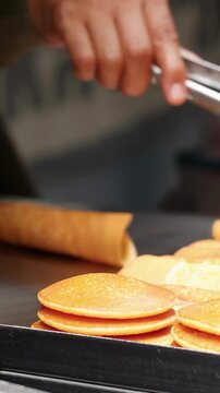 Street Vendor Rolling Thai Crepes on Hot Griddle