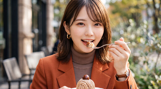 カフェのテラス席でモンブランケーキを美味しく食べる女性（秋のスイーツ・ご褒美・カフェ巡り）